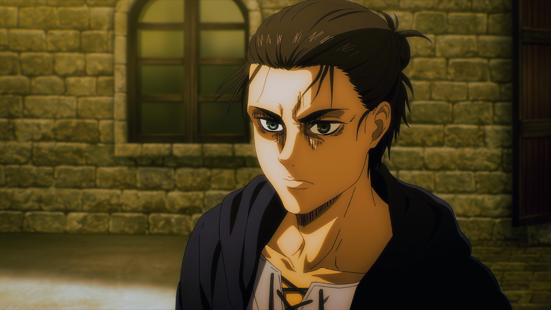 A young man with dark hair tied back glaring forward against a sunlit stone wall
